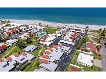 Aerial view of a beachfront community with a pool, tennis court, and easy access to beach at 500 Park S Blvd # 33, Venice, FL 34285