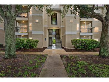 Condo exterior with beige siding, black balconies, and lush greenery at 5134 Northridge Rd # 303, Sarasota, FL 34238