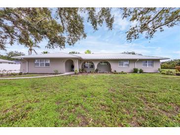 Charming single-story home featuring a metal roof, well-manicured lawn, and inviting curb appeal at 612 Bayshore Rd, Nokomis, FL 34275