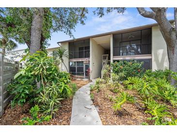 Condo exterior featuring well-maintained landscaping and mature trees, and screened in patios and balconies at 756 White Pine Tree Rd # 204, Venice, FL 34285
