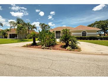 A single-story home with desert-style landscaping and a red tile roof under a blue sky with white clouds at 1136 Deardon Dr, Venice, FL 34292