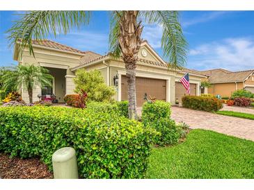 Inviting home featuring a brick driveway, lush landscaping, and a two-car garage at 11739 Okaloosa Dr, Venice, FL 34293