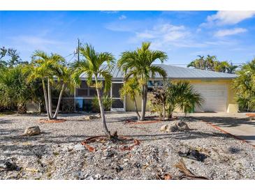 Charming single-story home featuring a metal roof, well-kept landscaping, and a lovely, serene curb appeal at 1350 Holiday Dr, Englewood, FL 34223