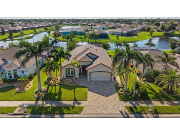 Beautiful waterfront home with lush landscaping, brick driveway and palm trees, creating a tropical paradise at 4260 Wordsworth Way, Venice, FL 34293