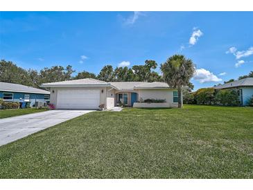 Charming single-story home with a well-manicured lawn and a classic white tiled roof at 903 E Shannon Ct, Venice, FL 34293