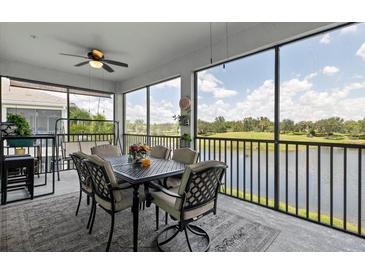 Screened lanai featuring a ceiling fan, outdoor dining set, and lovely views of the water at 935 Tidewater Shores # 721, Bradenton, FL 34208