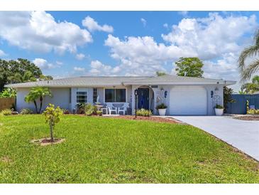 Charming one-story home with well-manicured lawn and landscaping and front porch seating at 1222 Pinebrook Way, Venice, FL 34285