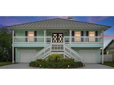 Charming two-story home with a double staircase, white railings, and a well-maintained landscaped yard at 334 7Th N Ave, Tierra Verde, FL 33715