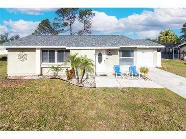 Charming single-story home featuring a well-maintained lawn and welcoming entrance with seating at 7585 Kavanda St, North Port, FL 34287