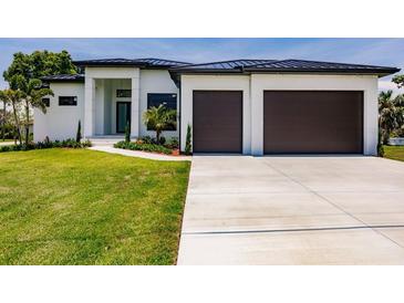 Modern two-story home with two-car garage and landscaped lawn at 24194 Peppercorn Rd, Punta Gorda, FL 33955