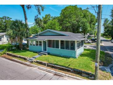 Charming bungalow with a light blue exterior, screened porch, and well-maintained lawn at 922 E Ida St, Tampa, FL 33603