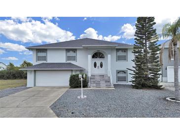Charming two-story home boasts a well-manicured front yard, a two car garage, and lovely curb appeal at 7438 Gulf Way, Hudson, FL 34667