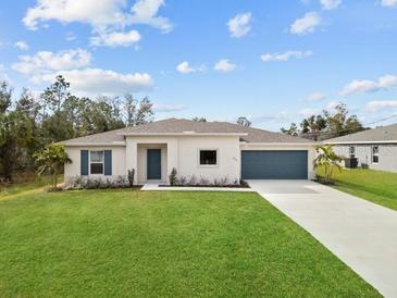 Single-story home with a two-car garage and a neatly landscaped lawn at 5255 Farmington Ave, North Port, FL 34288