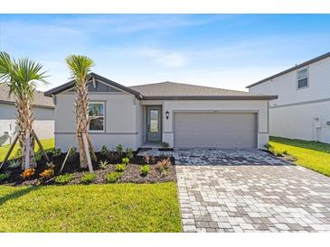 Single-story home with gray siding, two-car garage, and landscaping at 522 Sun Chaser Dr, Nokomis, FL 34275