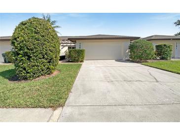Charming home featuring a two-car garage, well-maintained landscaping, and a concrete driveway at 7483 Carnoustie Dr # 5B, Sarasota, FL 34238