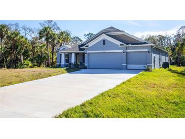 Charming single-story home with a three-car garage and long driveway at 5637 Ocarina Rd, North Port, FL 34291