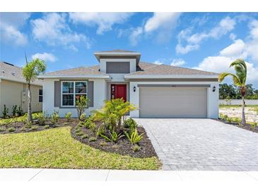 Charming single-Gathering home with a red door, landscaped yard, and a two-car garage at 9577 Vibrant Lane, Venice, FL 34292
