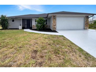 Charming single-story home with a well-manicured lawn and attached two car garage at 9308 San Bernandino Ave, Englewood, FL 34224