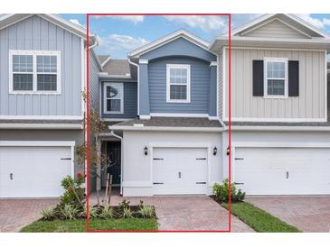 Charming two-story townhome with a brick driveway, attached garage, and professionally landscaped front yard at 17339 Peregrine Way, Punta Gorda, FL 33982