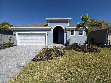 Charming single-Gathering home featuring a paved driveway, 2 car garage, and well-manicured landscaping at 9584 Vibrant Lane, Venice, FL 34292