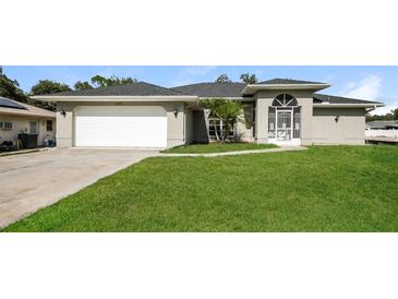 One-story house with a spacious lawn and attached garage at 1090 Yarmouth St, Port Charlotte, FL 33952