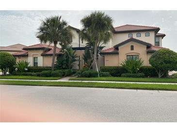 Charming two-story home with lush landscaping and a tile roof at 23598 Awabuki Dr # 102, Venice, FL 34293