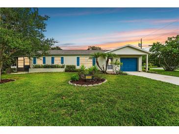 Charming single story home with blue garage door and landscaped lawn at 3300 Sea Grape Dr, Hernando Beach, FL 34607