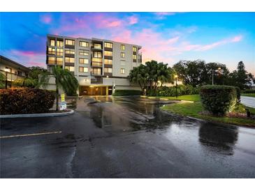 Exterior view of a condo building at dusk with parking lot and landscaping at 6219 Palma Del Mar S Blvd # 301, St Petersburg, FL 33715
