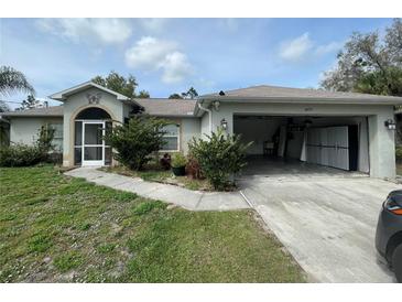 Single-story house with a two-car garage and landscaping at 4495 Amari Rd, North Port, FL 34291