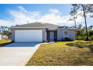 Charming one-story home with a large driveway and well-maintained lawn at 18059 Regan Ave, Port Charlotte, FL 33948