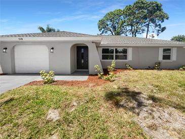 Newly renovated home with gray exterior and landscaping at 1340 Redstart Rd, Venice, FL 34293