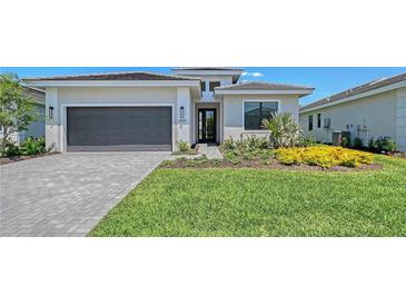 Charming single-story home boasts a meticulously landscaped front yard and attached two-car garage at 4990 Fairhope Cir, Lakewood Ranch, FL 34211