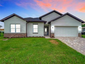 Modern house exterior with white siding, stone accents, and two-car garage at 2165 Music Ln, North Port, FL 34286