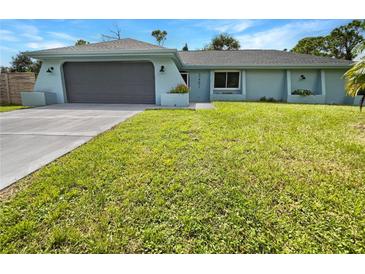 Newly renovated home with gray garage door and green lawn at 3451 Sage St, Port Charlotte, FL 33948