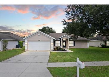 Single-story house with attached garage, landscaping, and a paved driveway at 7248 Periwinkle Ct, Brooksville, FL 34602