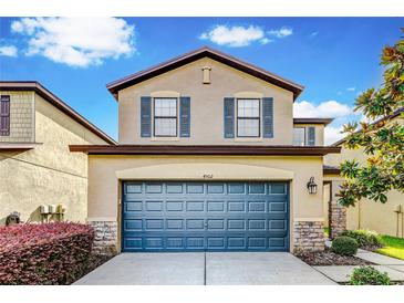 Two-story house with a blue garage door and landscaping at 4502 Banyan Tree Pl, Riverview, FL 33578