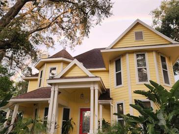 Charming yellow two-story house with wrap-around porch at 510 Wideview Ave, Tarpon Springs, FL 34689