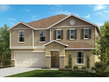 Two-story home with beige siding and three-car garage at 37496 Williamette Way, Zephyrhills, FL 33540