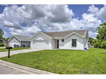 Newly constructed home with white siding, a two-car garage, and a landscaped lawn at 3540 65Th Avenue E Cir, Sarasota, FL 34243