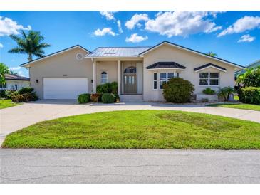 Tan house with a large garage and manicured lawn at 265 Belvedere Ct, Punta Gorda, FL 33950