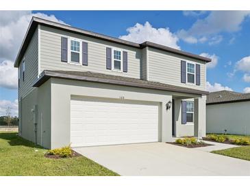 Two-story house with gray siding, white garage, and landscaping at 168 Lazy Shore Dr, Nokomis, FL 34275