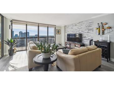 Bright living room features a stone accent wall and expansive windows with city views at 2413 Bayshore Blvd # 1404, Tampa, FL 33629