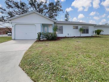 Ranch-style home with attached garage and lawn at 8381 Chelsea Ct, North Port, FL 34287