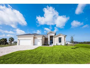 Beautiful home showcasing a well-manicured lawn and a spacious three-car garage at 17013 Alpenhorn Ct, Punta Gorda, FL 33955