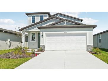 Two-story home with a light gray facade, complemented by a two-car garage and simple landscaping at 14044 Crutchfield Ct, Parrish, FL 34219