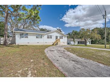 White single-story home with a gravel driveway at 11335 Pickford St, Spring Hill, FL 34609