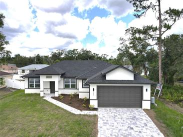 Beautiful single-story home with a modern design, paver driveway, and well-maintained landscaping at 4683 Boston Ter, North Port, FL 34288
