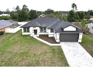 Charming new construction with paver driveway and neutral colors in a nicely landscaped neighborhood at 1081 Mccrory St, North Port, FL 34286