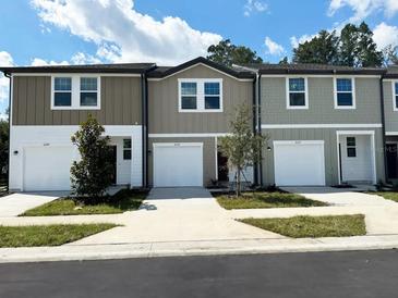 Three-unit townhome building with attached garages and neutral-toned siding at 11839 Sylvia St, Dade City, FL 33525