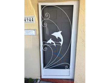 White metal front door with dolphin design at 4944 Hazner St # 4944, New Port Richey, FL 34652